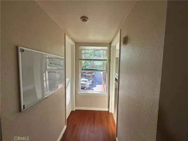 a view of a hallway with wooden floor and doors
