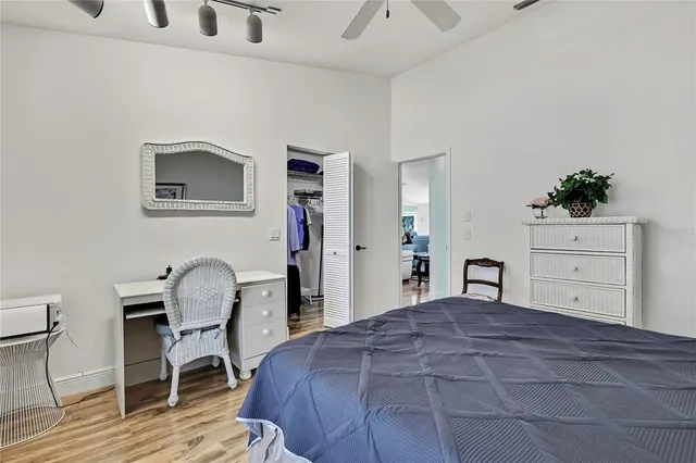 a bedroom with a bed and a dresser with wooden floor