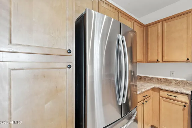 a view of a kitchen with a refrigerator and cabinets