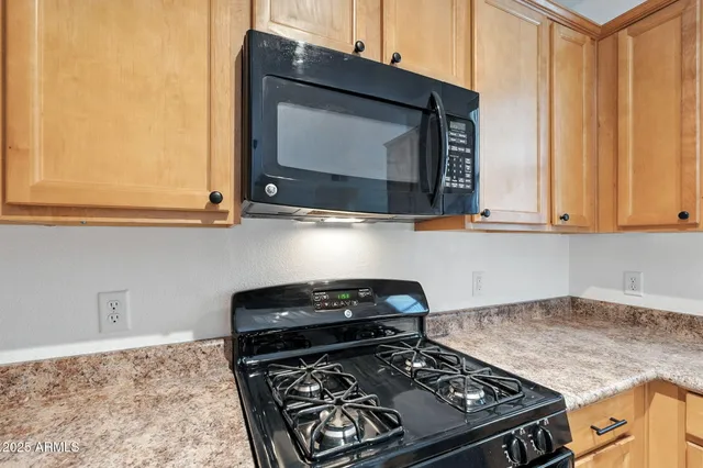 a kitchen with stainless steel appliances granite countertop a stove and a microwave