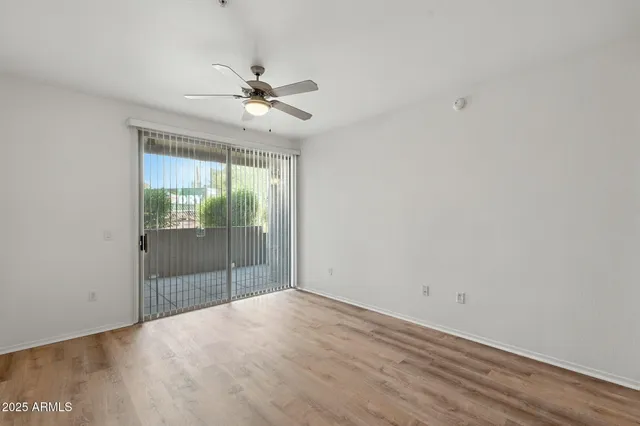 a view of a room with wooden floor and fan