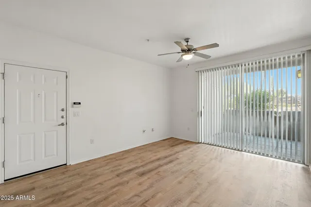 an empty room with fan and windows