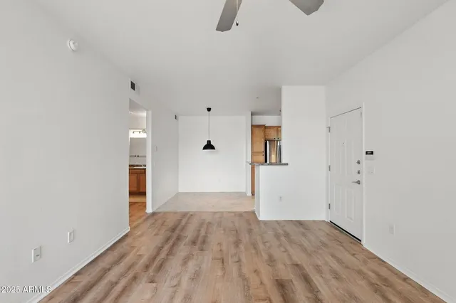 a view of wooden floor in an empty room with a window