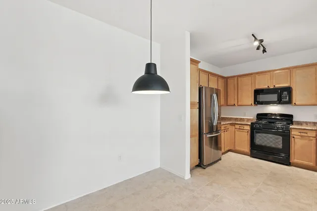 a kitchen with stainless steel appliances granite countertop a refrigerator a stove a sink and a microwave