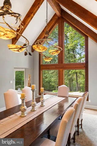 a view of a patio with couches potted plants and a wooden bench