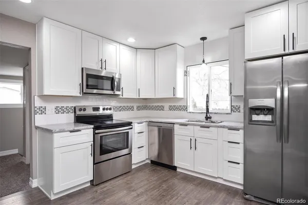 a kitchen with white cabinets and stainless steel appliances