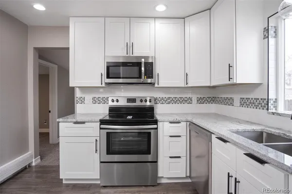 a kitchen with cabinets stainless steel appliances and sink