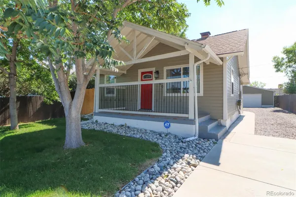 a view of a white house with a big yard and large tree