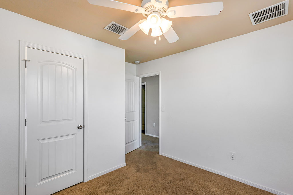 12105 Greywacke Drive Manor, TX 78653 - Photo 16 of 18 an empty room with a chandelier fan and closet area