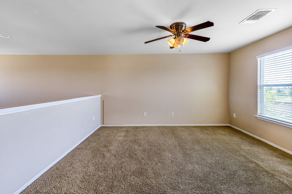 12105 Greywacke Drive Manor, TX 78653 - Photo 6 of 18 an empty room with window and ceiling fan
