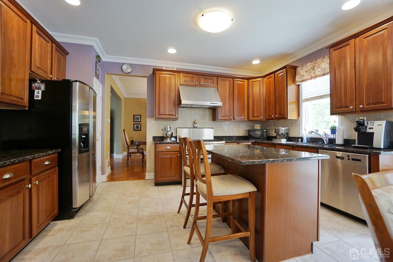 54 Stratton Road Old Bridge, NJ 07747 - Photo 6 of 23 a kitchen with stainless steel appliances granite countertop a refrigerator a stove a sink a dining table and chairs