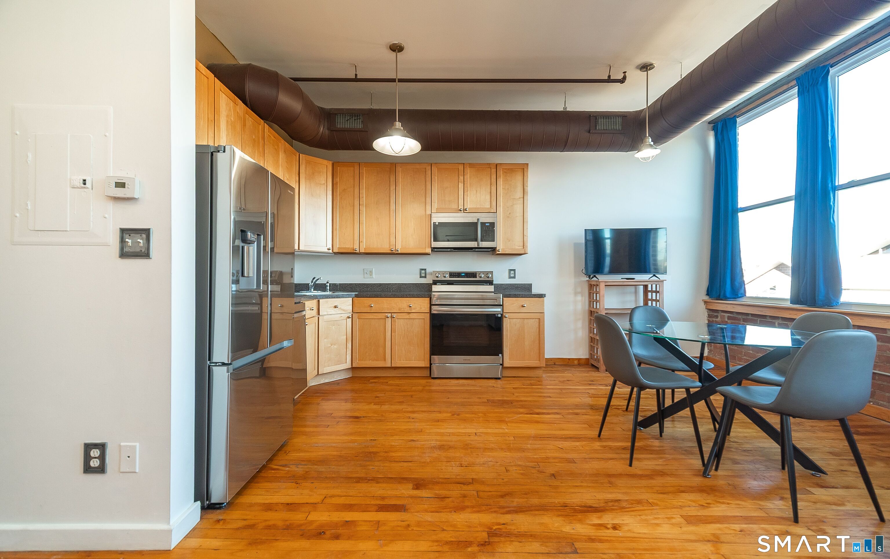 325 Lafayette Street, Unit 8205 Bridgeport, CT 06604 - Photo 4 of 23 a kitchen with stainless steel appliances granite countertop a stove top oven a sink dishwasher a dining table and chairs with wooden floor