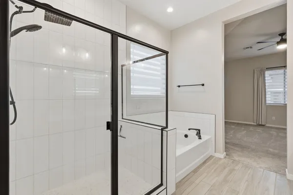 a bathroom with a glass shower door and a bathtub