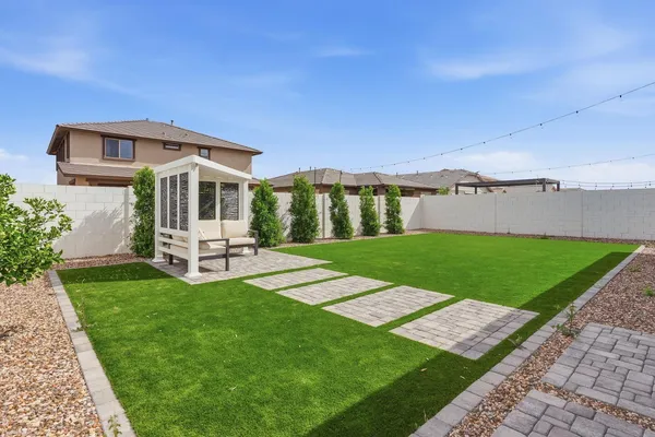 a kitchen with stainless steel appliances granite countertop a sink a stove a refrigerator and island with wooden floor