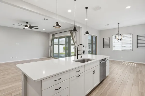 a kitchen with a sink a refrigerator and cabinets