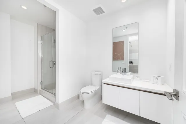 a spacious bathroom with a toilet sink and mirror