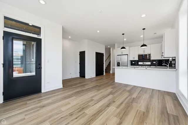a view of kitchen with granite countertop cabinets and refrigerator