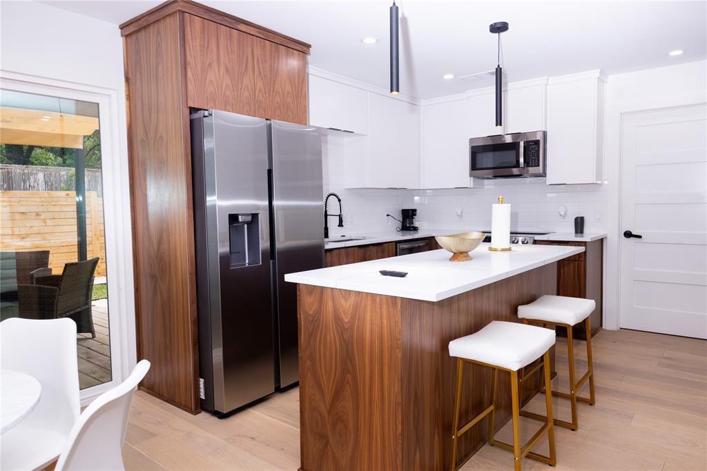 1402 Braes Ridge Drive, Unit B Austin, TX 78723 - Photo 4 of 13 a kitchen with stainless steel appliances a stove a sink a refrigerator and chairs