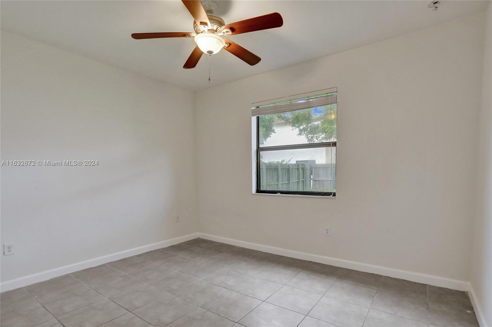 588 Southeast 35th Terrace Homestead, FL 33033 - Photo 13 of 37 an empty room with a window and a fan