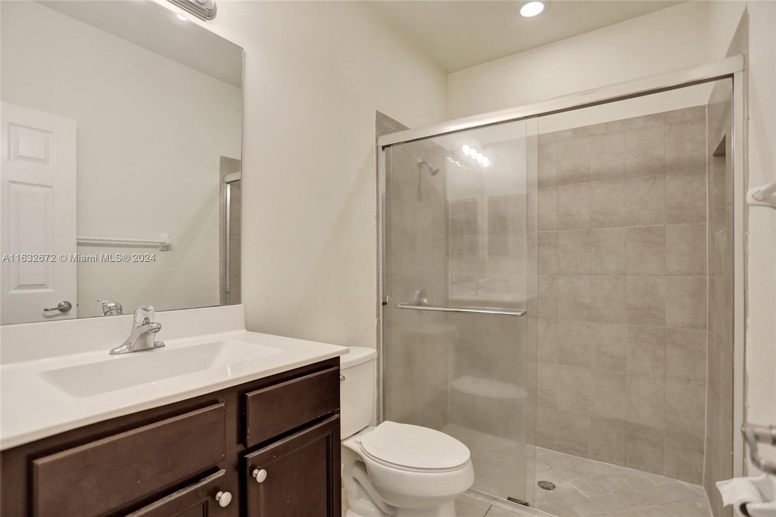 588 Southeast 35th Terrace Homestead, FL 33033 - Photo 15 of 37 a bathroom with a sink mirror vanity and toilet