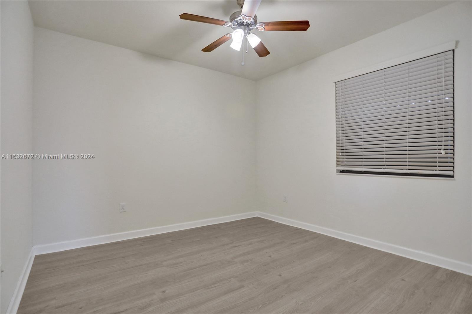 588 Southeast 35th Terrace Homestead, FL 33033 - Photo 19 of 37 a view of an empty room with wooden floor and a window