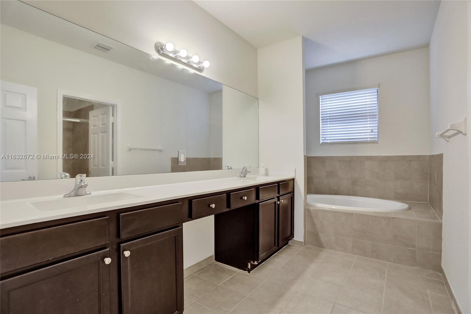 588 Southeast 35th Terrace Homestead, FL 33033 - Photo 24 of 37 a bathroom with a sink a large mirror and a bathtub