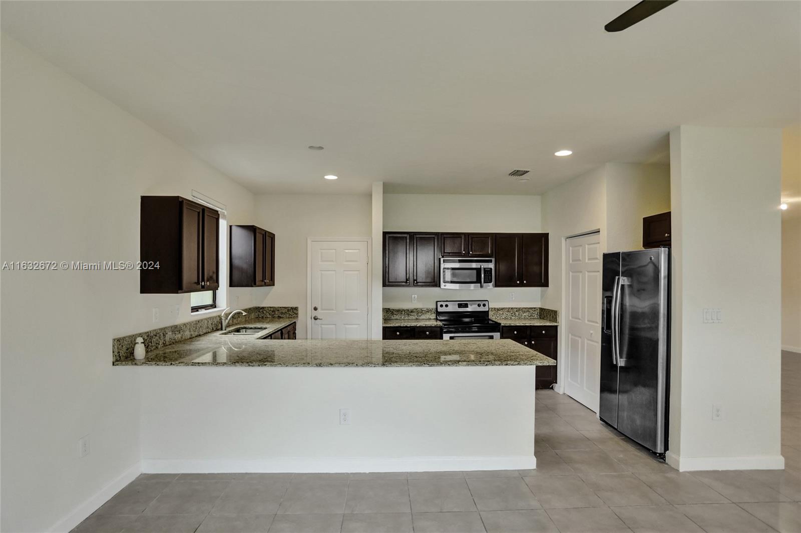 588 Southeast 35th Terrace Homestead, FL 33033 - Photo 8 of 37 a large kitchen with stainless steel appliances a refrigerator a stove a sink a washer and dryer