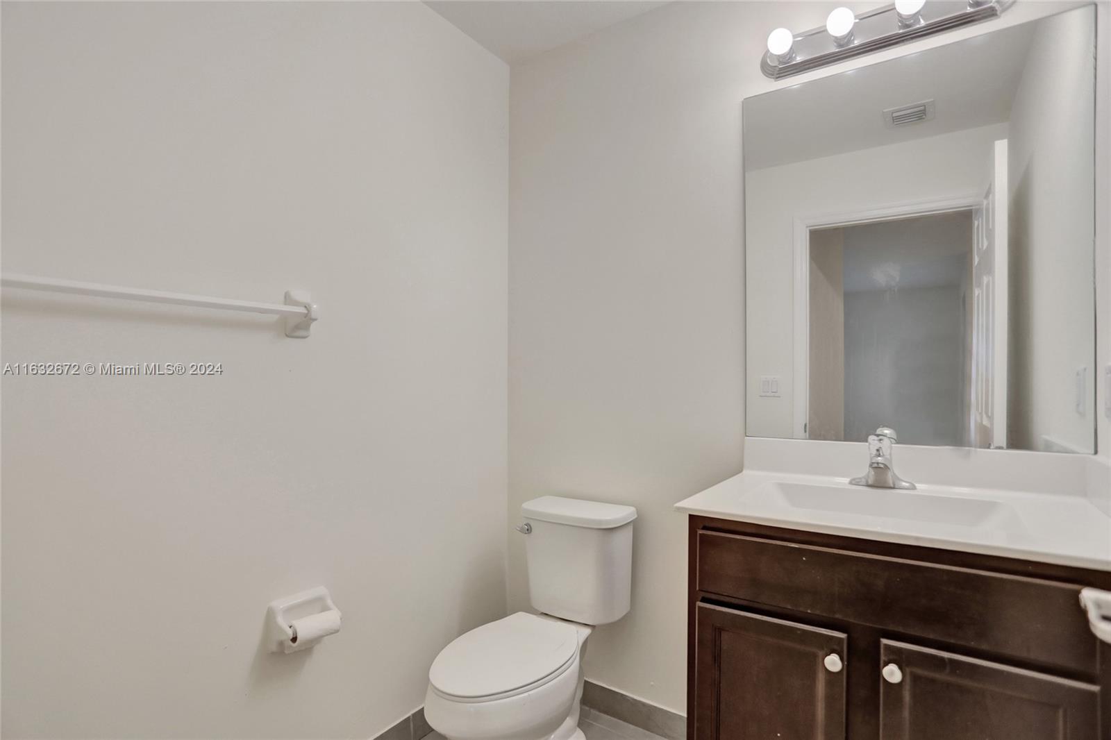 588 Southeast 35th Terrace Homestead, FL 33033 - Photo 10 of 37 a bathroom with a sink a toilet and a mirror