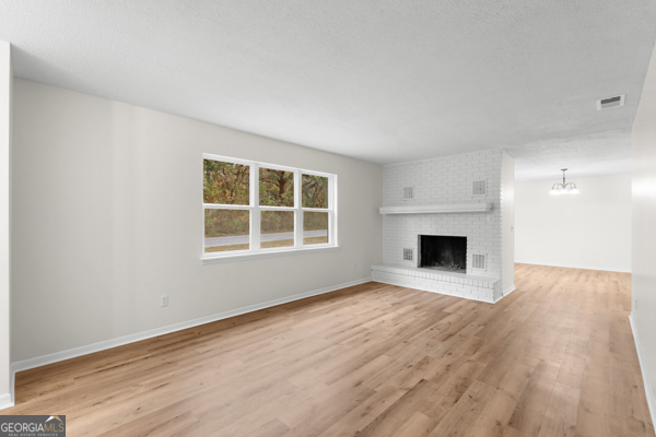 529 College Heights Road Portal, GA 30450 - Photo 10 of 23 a view of empty room with wooden floor and fireplace