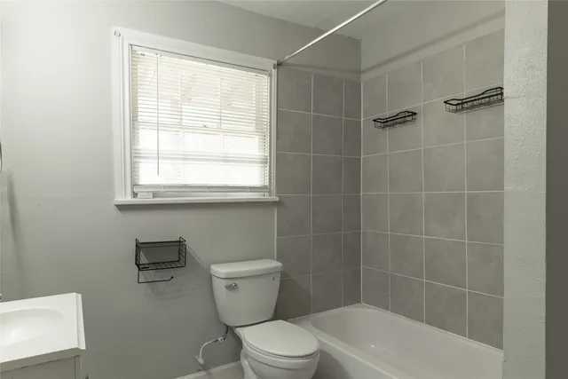 a white toilet sitting next to a bath tub