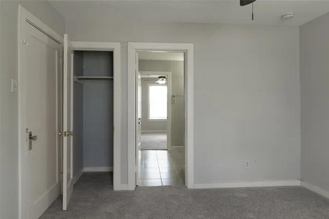 a view of an empty room with glass door and a window