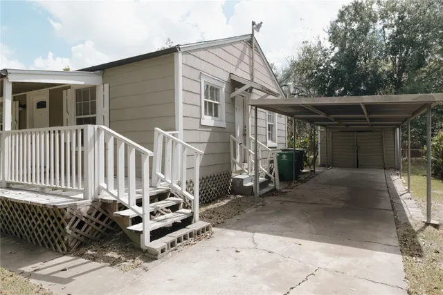 a view of a house with a small yard and wooden fence