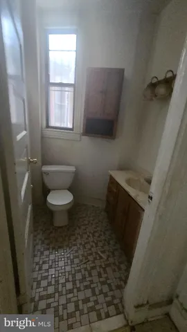 a bathroom with a sink toilet and window