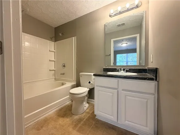 a bathroom with a toilet a sink a mirror and a bathtub
