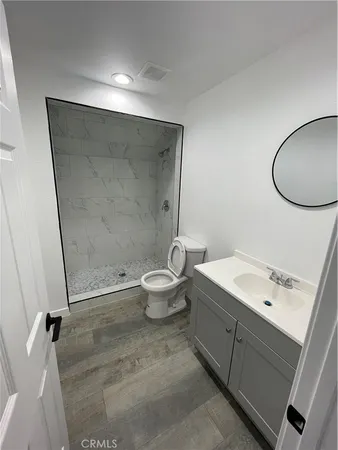 a bathroom with a granite countertop sink toilet and a mirror