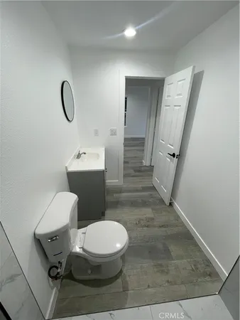 a white toilet sitting next to a bathroom sink and a mirror