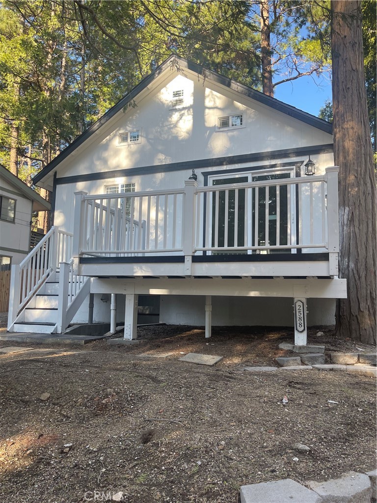 2588 Secret Drive Running Springs, CA 92382 - Photo 3 of 24 a backyard of a house with a deck and a yard