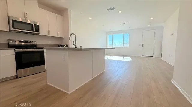 a kitchen with granite countertop a stove and a wooden floor