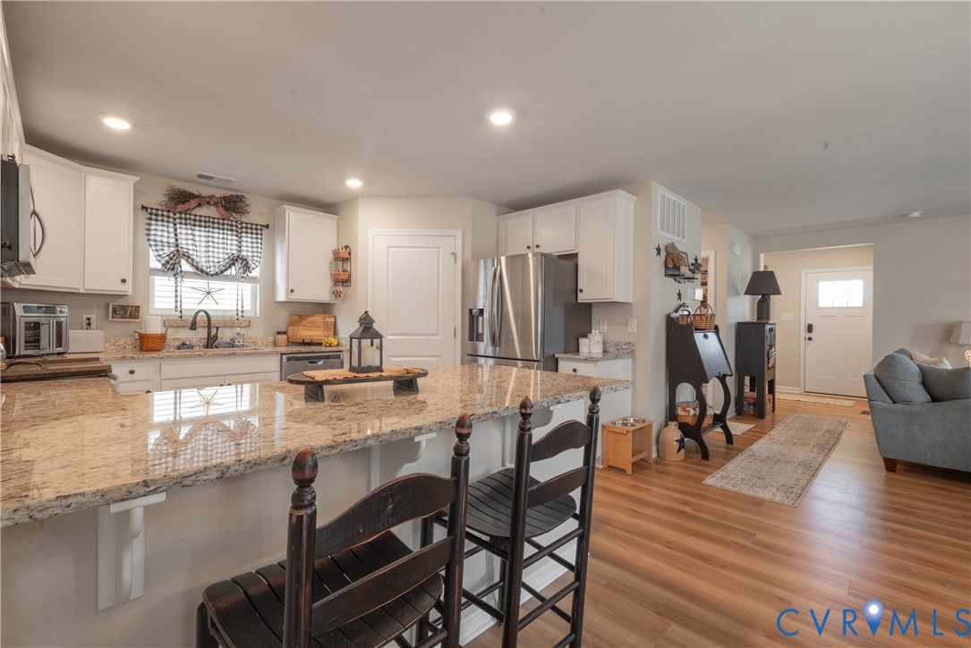 17854 Meriwether Lewis Street Ruther Glen, VA 22546 - Photo 13 of 39 Kitchen featuring white cabinetry, light-toned cou