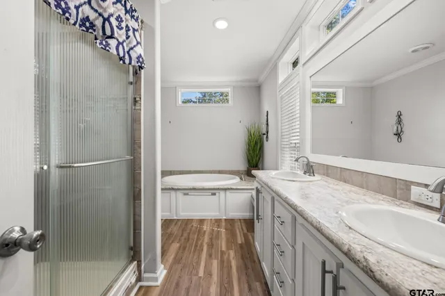 a bathroom with a granite countertop double vanity sink and mirror