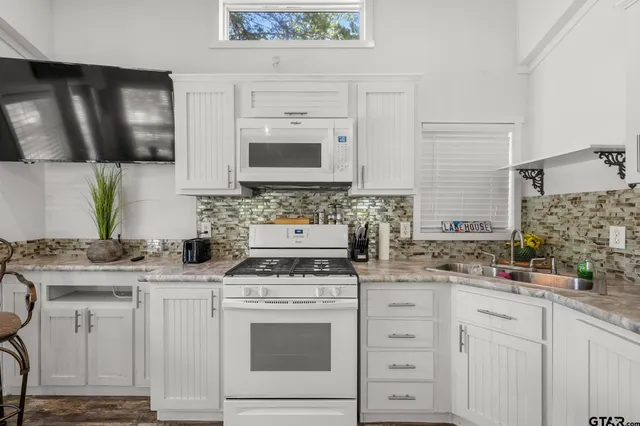 a kitchen with cabinets appliances a sink and a counter top