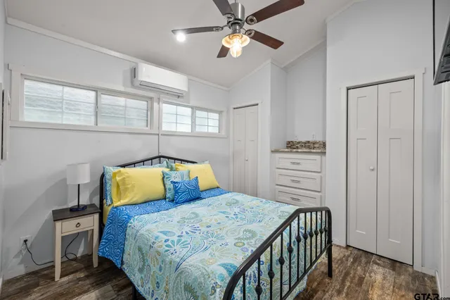 a bedroom with a bed a dresser and a chandelier