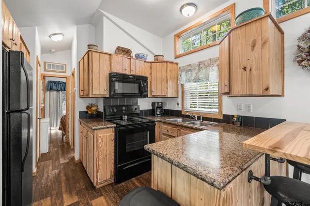 a kitchen with stainless steel appliances granite countertop a stove a sink and a refrigerator