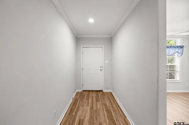 a view of a room with wooden floor and bench