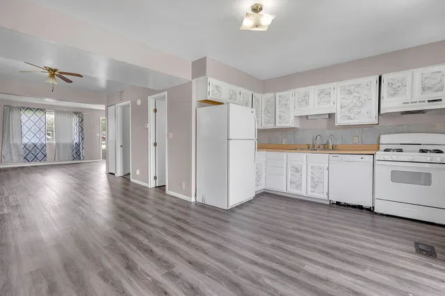 a view of a kitchen with a white appliances cabinets and a wooden floor