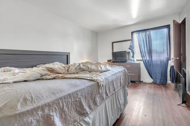 a bedroom with a bed a mirror and a dresser