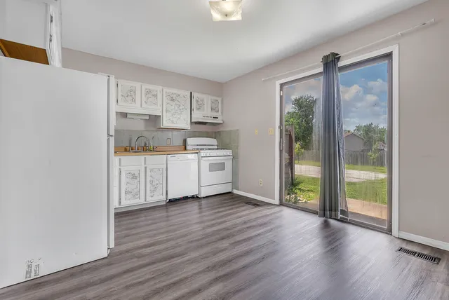 a view of kitchen with wooden floor and electronic appliances