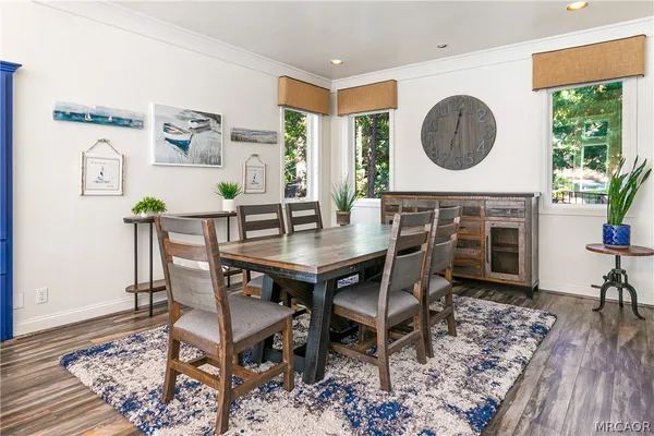 a dining room with furniture a kitchen view and wooden floor