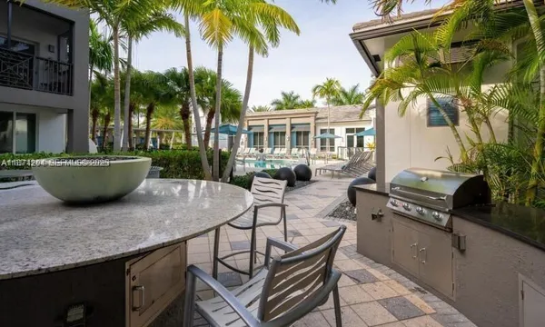 a view of a patio with table and chairs potted plants and floor to ceiling window
