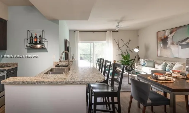 a dining room with kitchen island granite countertop furniture a chandelier and kitchen view